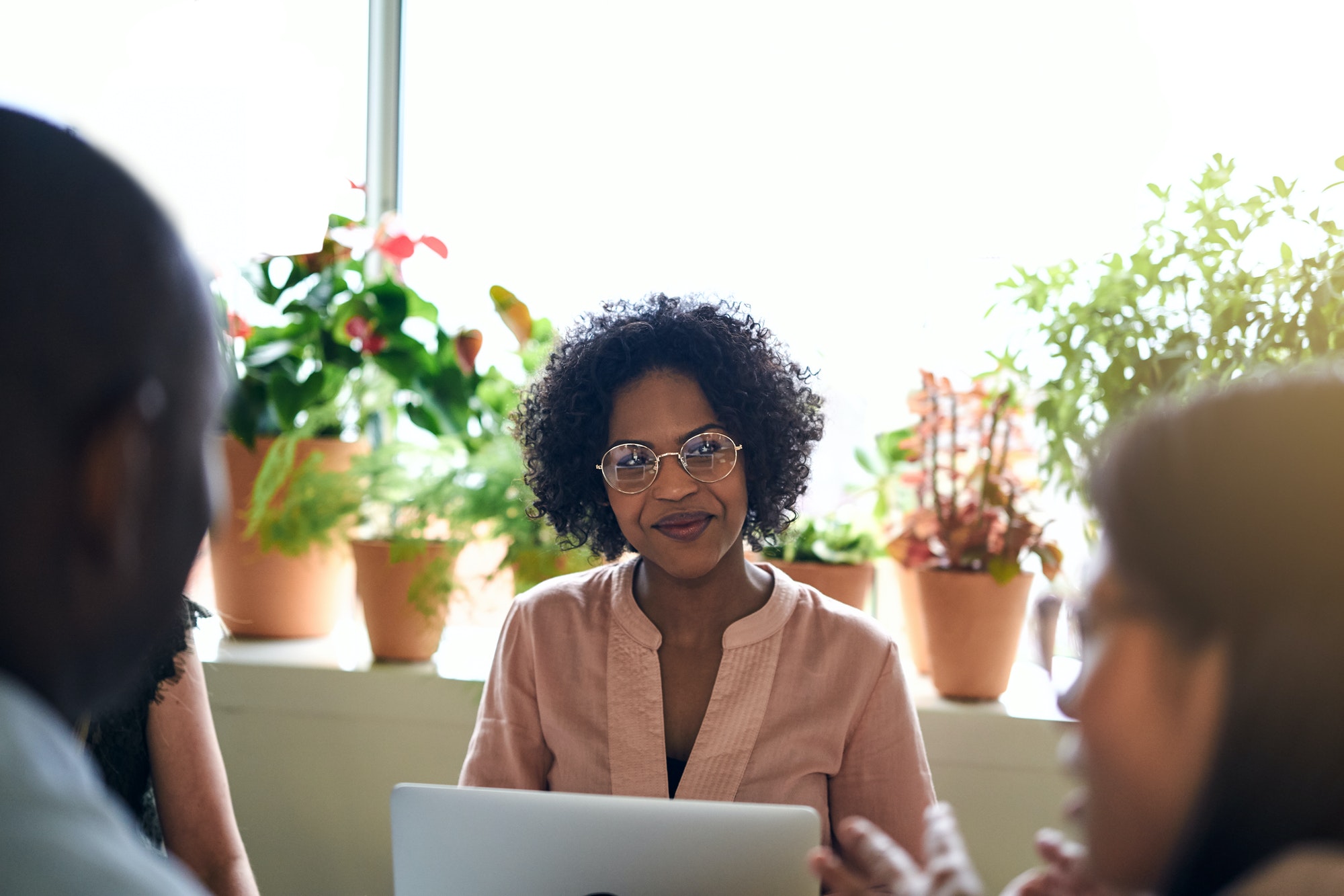 Smiling African businesswoman meeting with colleagues in an office